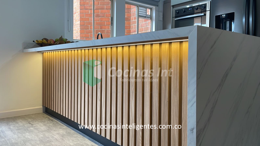 Cocina en madera ecológica en colores fresno europeo y taupe, con una isla que luce un impresionante mesón sinterizado Panda Grey